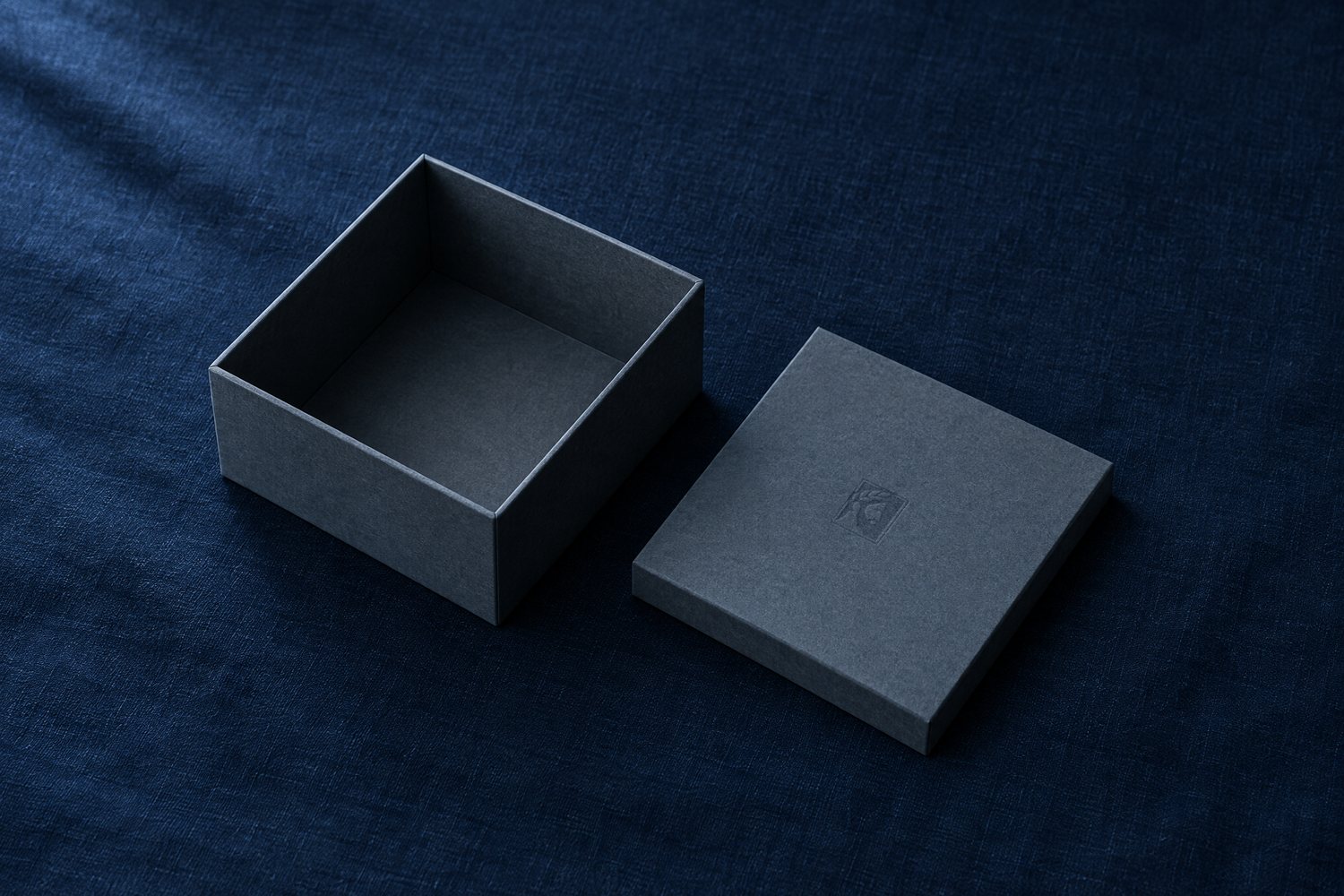 An empty slate-grey box with its lid set beside it, the Olivent mark pressed into the lid