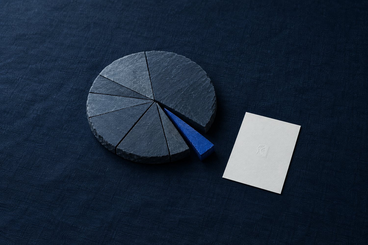 A slate disc cut into wedges with one cobalt wedge pulled out, beside a white card embossed with the Olivent mark